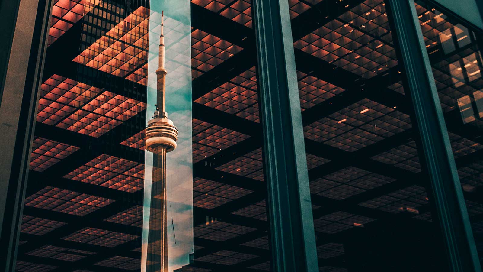 Should Canada create a Startup Visa for immigrant entrepreneurs? img showing reflection of CN tower in the window of large office tower