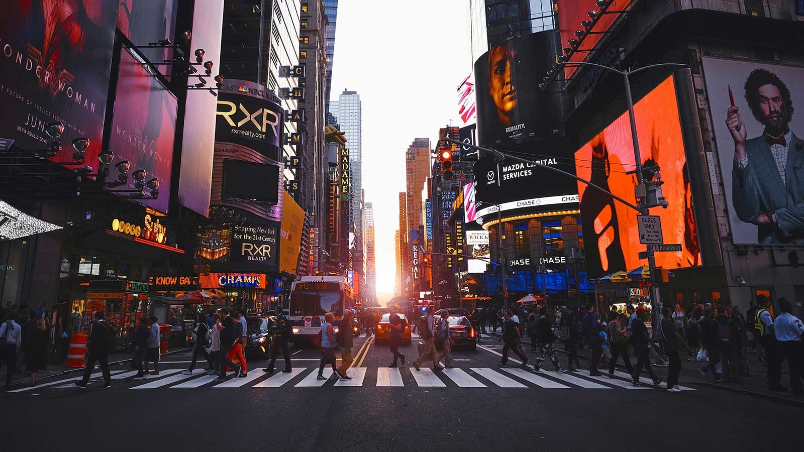 Will the US follow Canada’s entrepreneur visa lead? img showing times square in New York with people crossing the street and sunset behind them